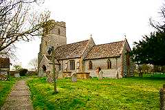 Stone building with prominent square tower.
                        In the foreground are gravestones.