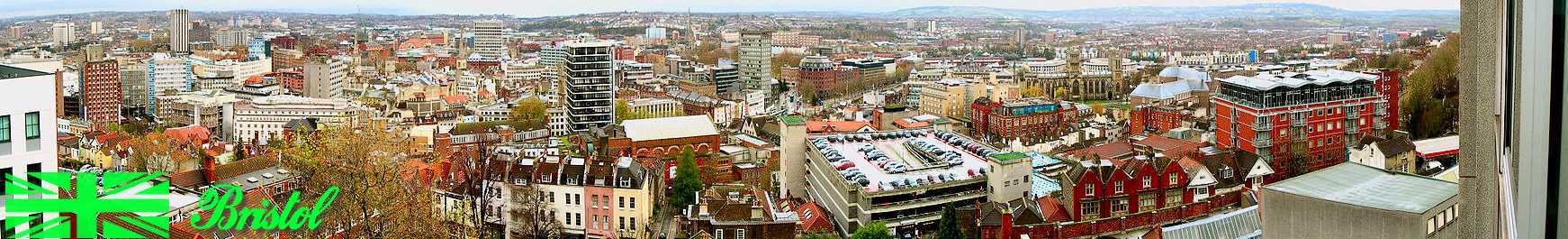 A panoramic view looking over a
                                cityscape of office blocks, old
                                buildings, church spires and a
                                multi-story car park. In the distance
                                hills.